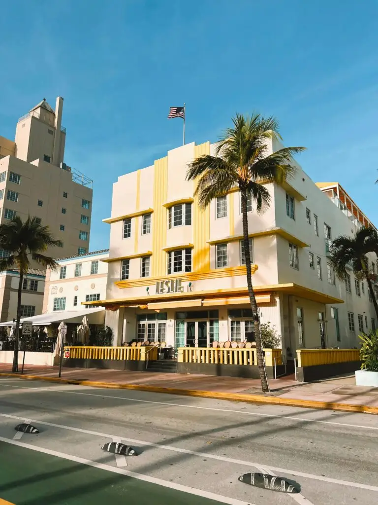 Vibrant Art Deco buildings with palm trees and clear sky in South Beach Miami.